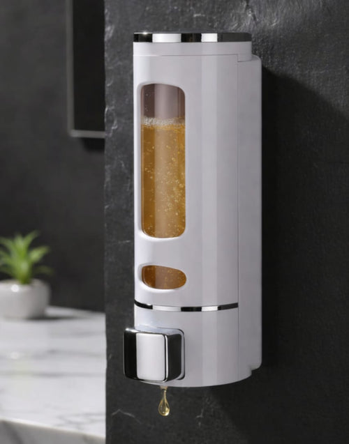 Wall-mounted soap dispenser with soap inside, displayed against a dark wall.