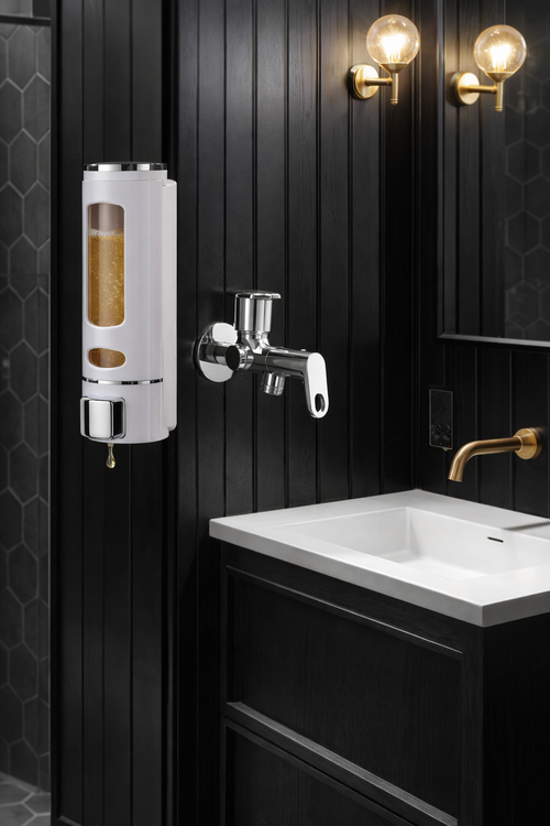 Bathroom with black paneled walls, white sink, and gold faucet.